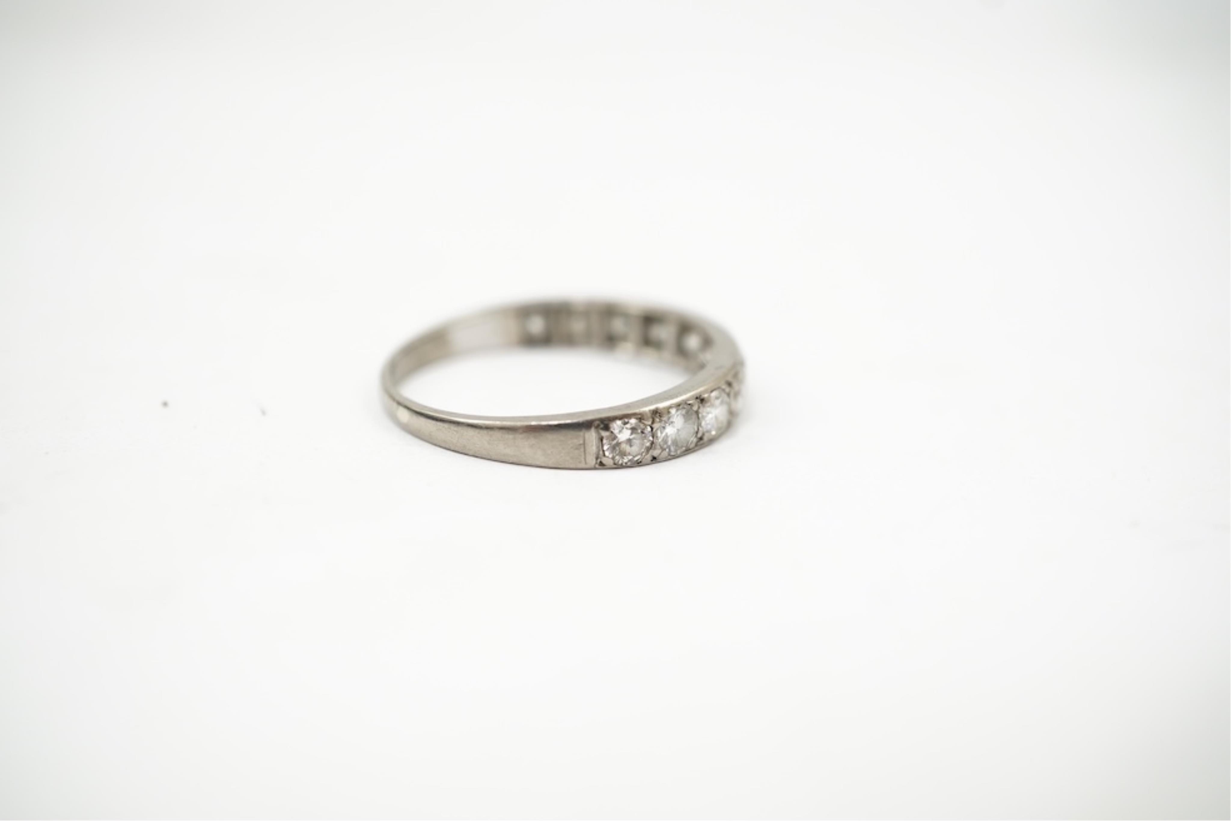 An 18ct white metal and graduated eleven stone diamond set half eternity ring, size P/Q. gross weight 3 grams.